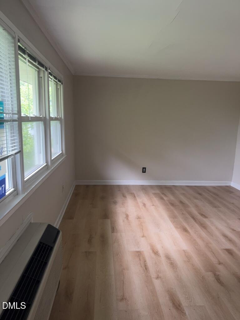 703 Daniels Street, Unit C Raleigh, NC 27605 - Photo 2 of 8 an empty room with wooden floor and windows