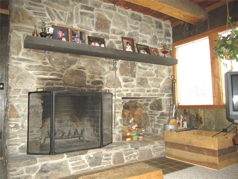 Just Stunning! Mountain stone faced, oversized, wood burning fireplace with built in log storage to the right!