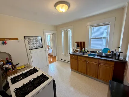a kitchen with sink stove and refrigerator