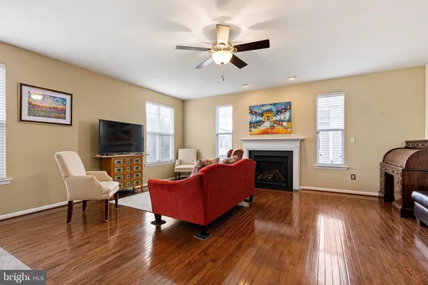 a living room with furniture a ceiling fan and a window