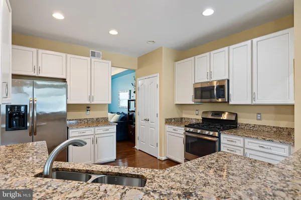 a kitchen with a refrigerator sink and cabinets