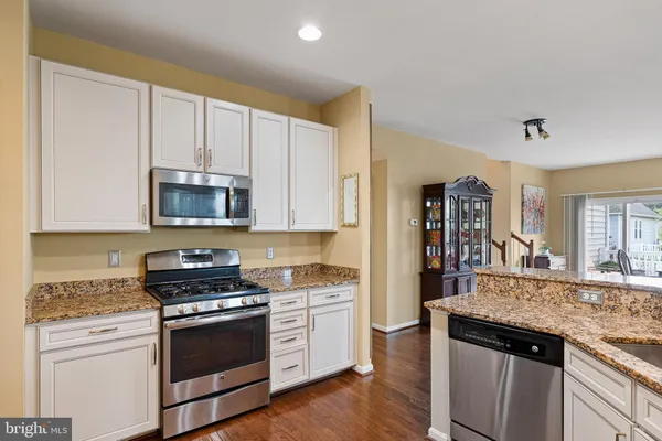 a kitchen with stainless steel appliances granite countertop a stove and cabinets