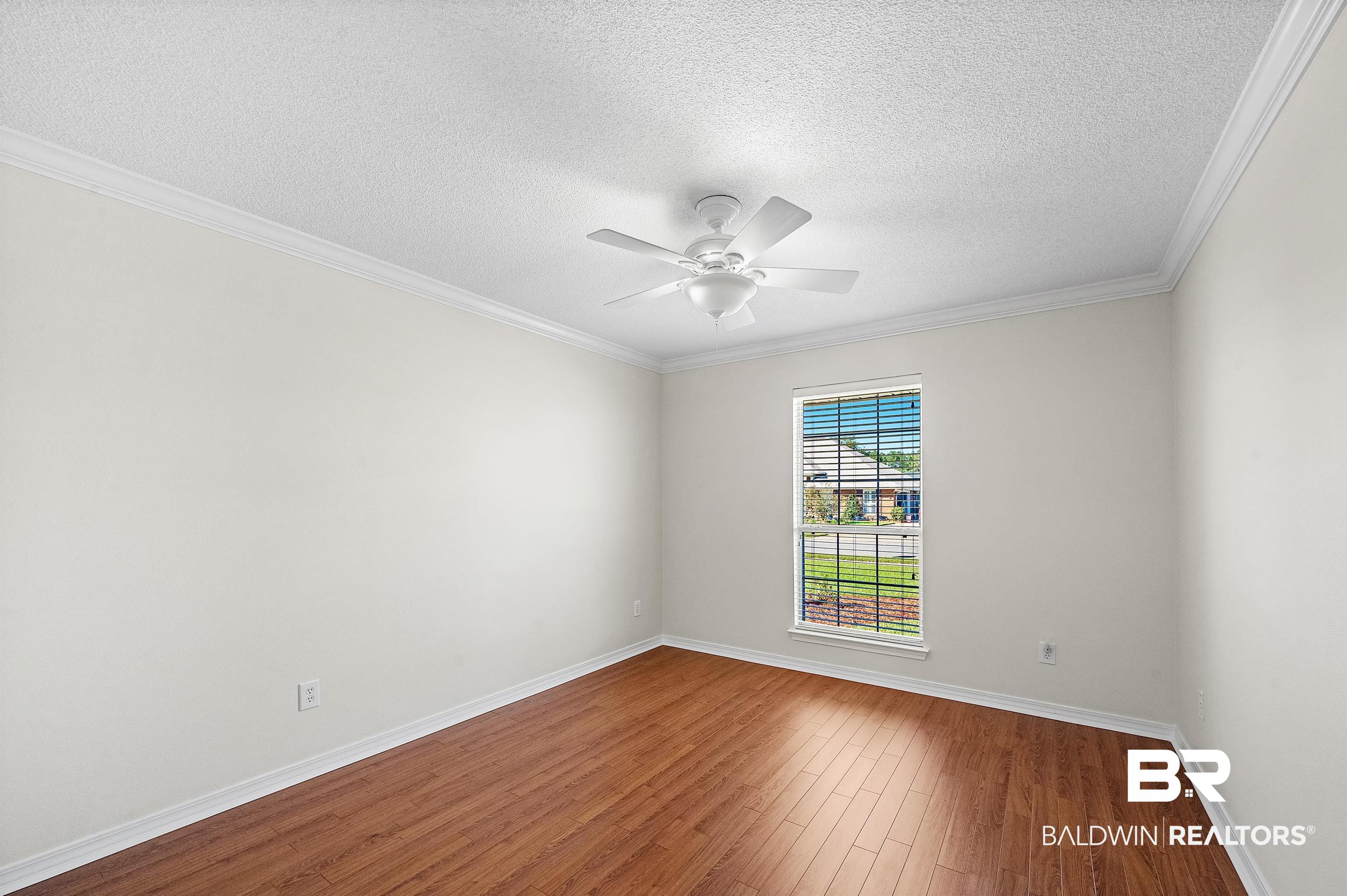 421 Collinwood Loop Foley, AL 36535 - Photo 45 of 62 Unfurnished room with ornamental molding, a textured ceiling, wood-type flooring, and ceiling fan