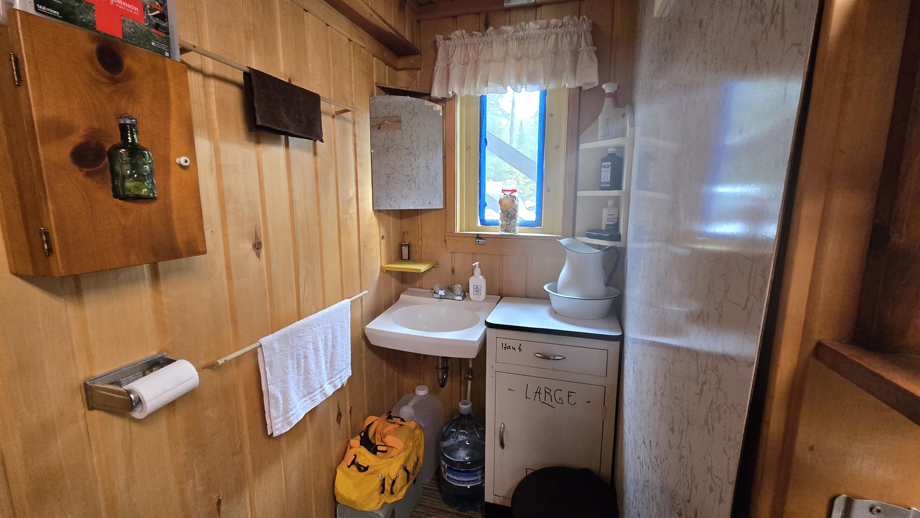 7178 Gold Mine Road Orr, MN 55771 - Photo 18 of 36 Bathroom featuring wood walls and a sink