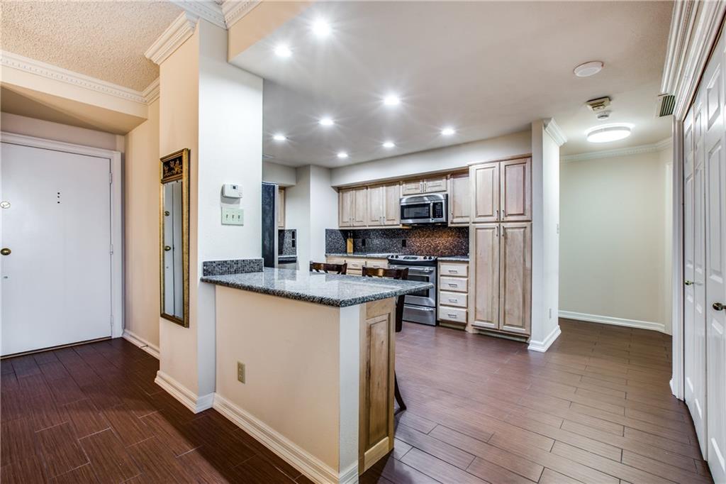 5200 Keller Springs Road, Unit 537 Dallas, TX 75248 - Photo 1 of 1 a kitchen with stainless steel appliances granite countertop a refrigerator a stove and a wooden floors