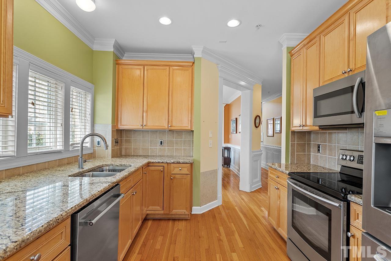 203 Towne Ridge Lane Chapel Hill, NC 27516 - Photo 14 of 38 a kitchen with stainless steel appliances granite countertop a sink a stove a refrigerator cabinets and a window