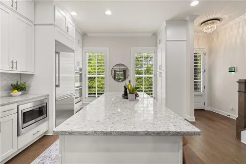 a view of a kitchen counter space wooden floor electronic appliances and windows