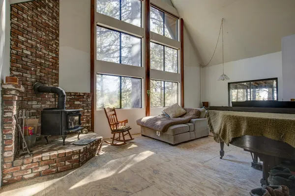 a living room with furniture and a piano next to a large window