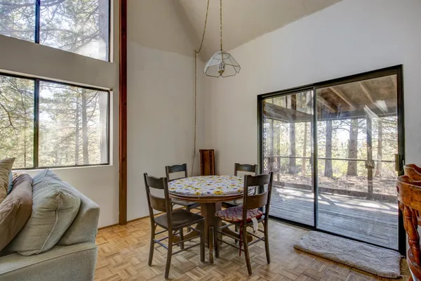 a view of a hallway with wooden floor and a bathroom