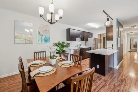 a dining room with furniture a rug and wooden floor