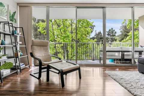 a living room with furniture a flat screen tv and a large window