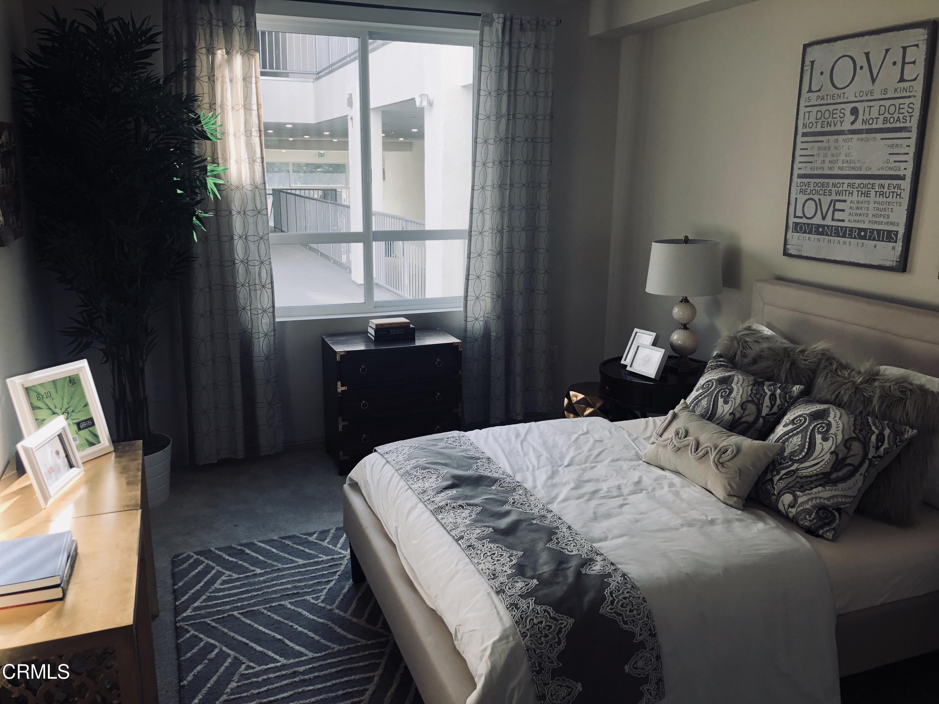 300 West 9th Street Oxnard, CA 93030 - Photo 11 of 12 a bedroom with a bed and wooden floor