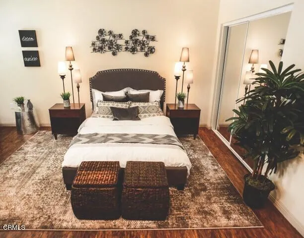a bed sitting in a bedroom next to a window with potted plants