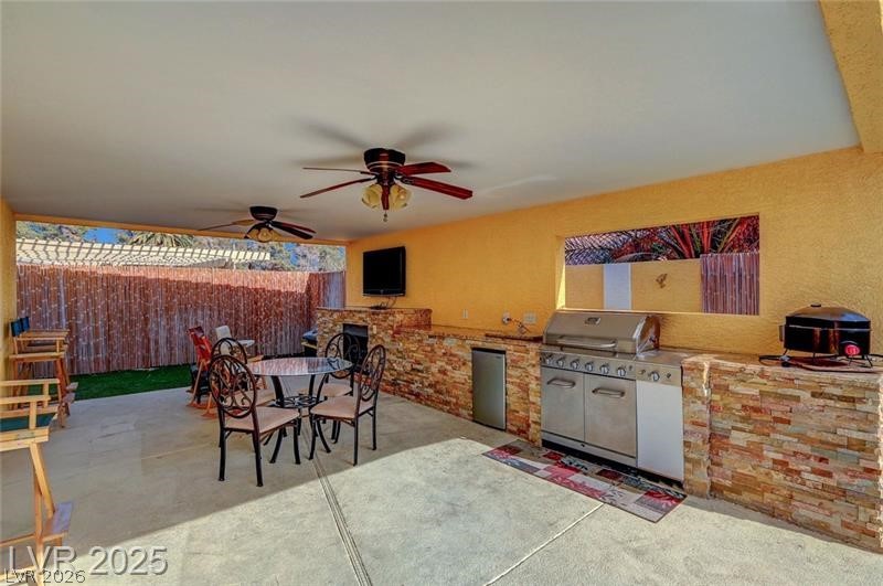 2410 Doherty Way Henderson, NV 89014 - Photo 57 of 63 View of patio with exterior kitchen, a ceiling fan, fence, and outdoor dining area