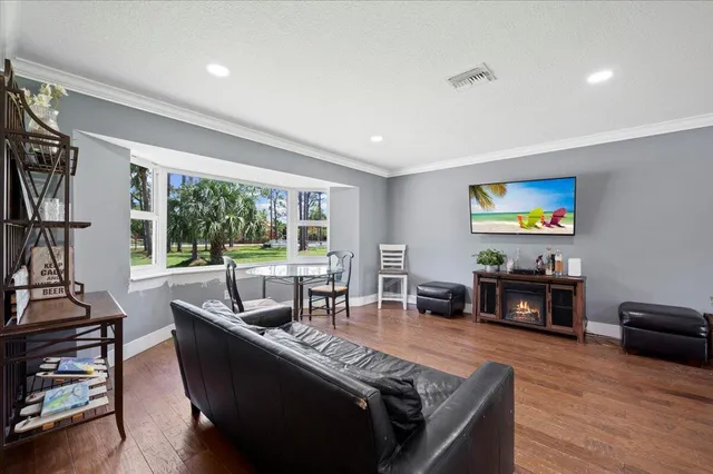 a living room with furniture and a flat screen tv with wooden floor