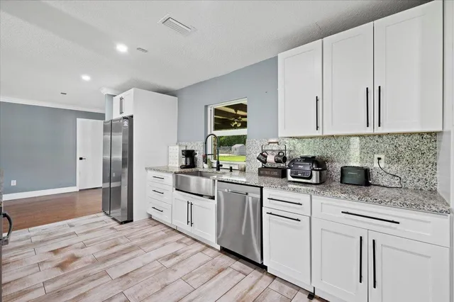 a kitchen with white cabinets and stainless steel appliances
