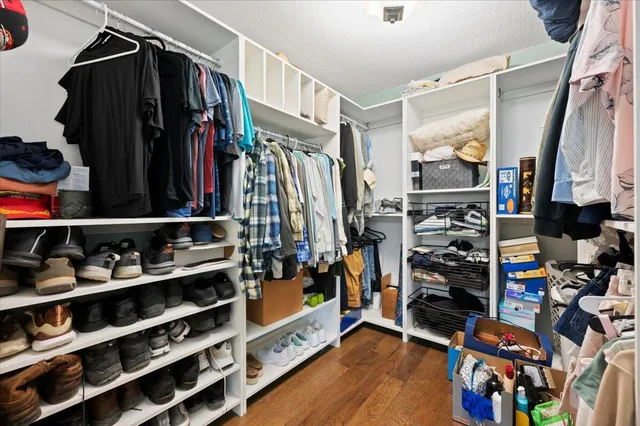 a view of walk in closet with clothes and shoes