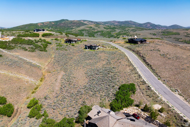 3508 Ridgeway Drive, Unit 31 Heber City, UT 84036 - Photo 9 of 13 Expansive hillside property featuring a paved road, scattered natural vegetation, and distant mountain topography