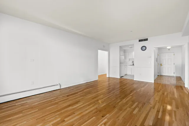 a view of empty room with wooden floor