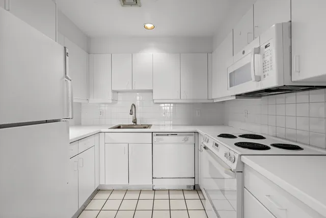 a kitchen with cabinets appliances a sink and a counter top space
