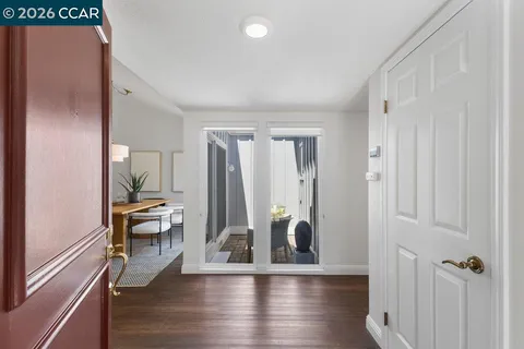 a view of a hallway with wooden floor and windows