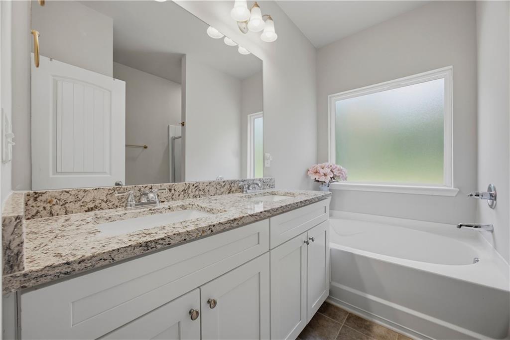 70 Gold Mine Road Grantville, GA 30220 - Photo 13 of 23 a bathroom with a granite countertop sink a mirror and a bathtub