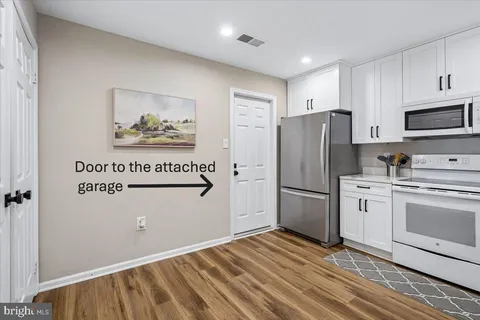 a kitchen with stainless steel appliances kitchen island a table and chairs in it