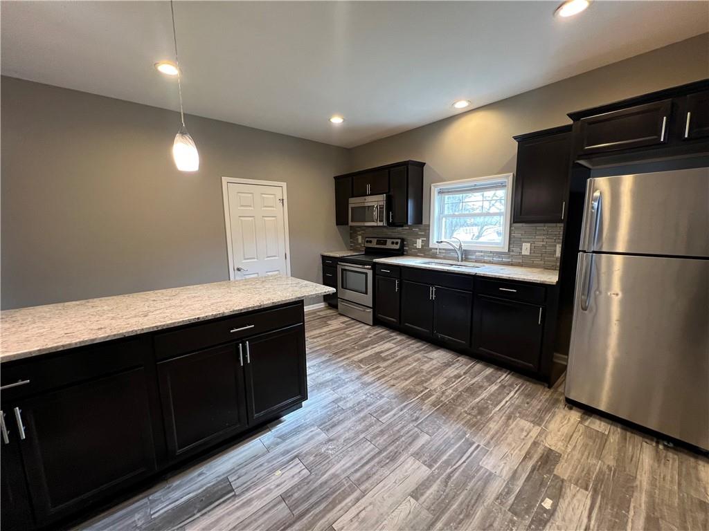 1105 Riverside Drive, Unit 1 Beaver, PA 15009 - Photo 9 of 20 a kitchen with stainless steel appliances granite countertop wooden cabinets a refrigerator a sink a stove and wooden floors