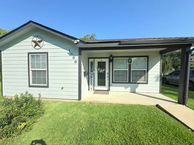 a view of a house with a large window and a yard