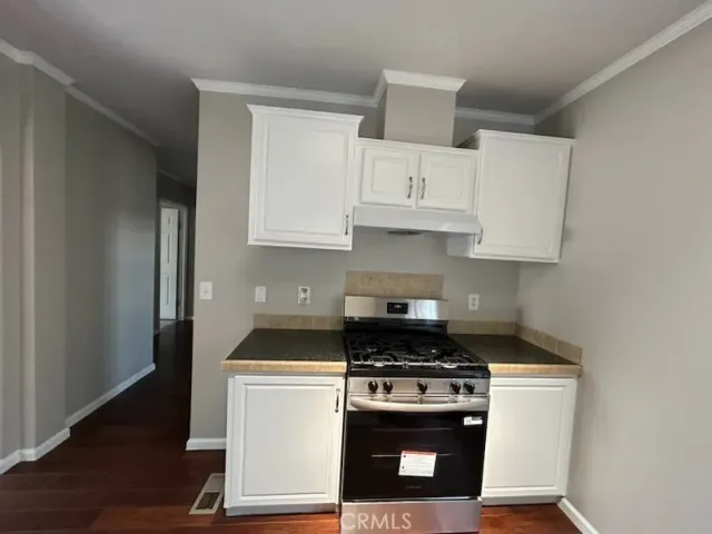 a kitchen with white cabinets and appliances