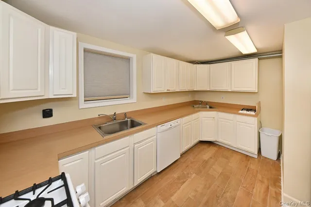a kitchen with granite countertop white cabinets and white appliances