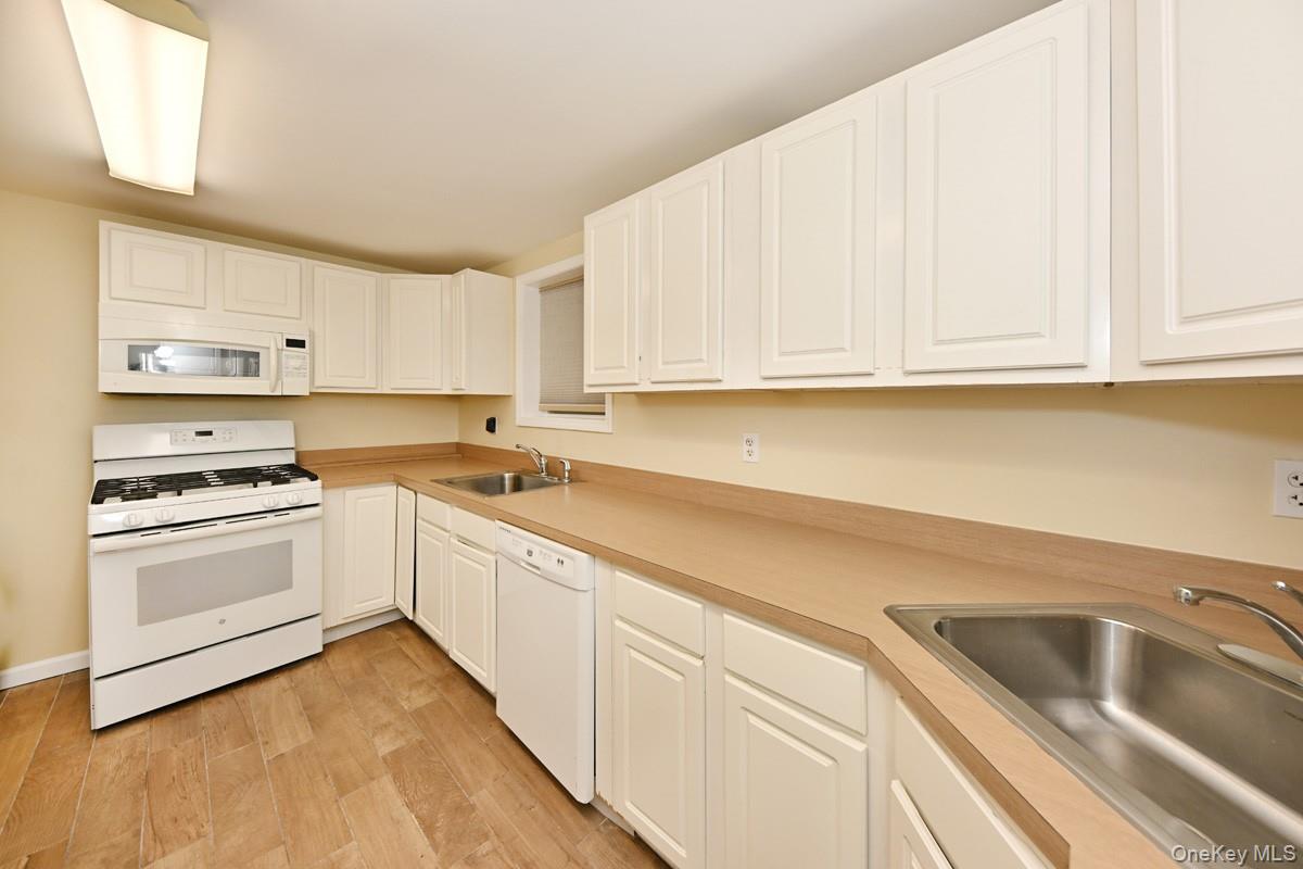 2 Elener Lane Spring Valley, NY 10977 - Photo 22 of 30 a kitchen with granite countertop white cabinets and white appliances