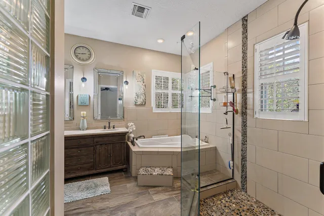 a bathroom with a double vanity sink a toilet a mirror and shower