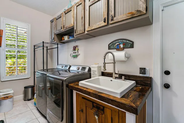 a utility room with stainless steel appliances granite countertop a sink stove and cabinets
