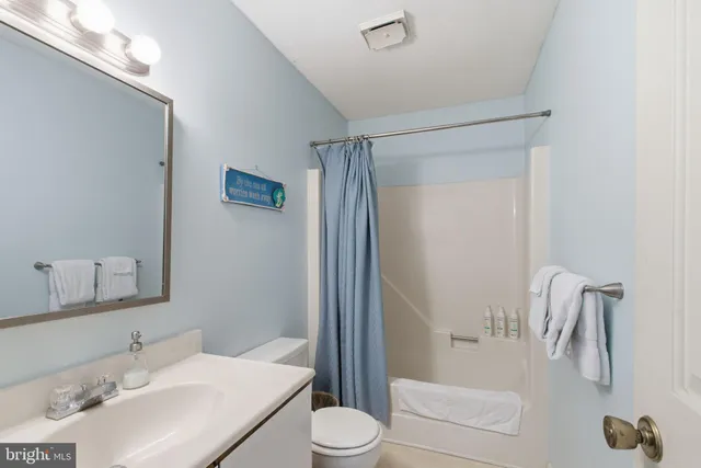 a bathroom with a sink vanity granite and toilet