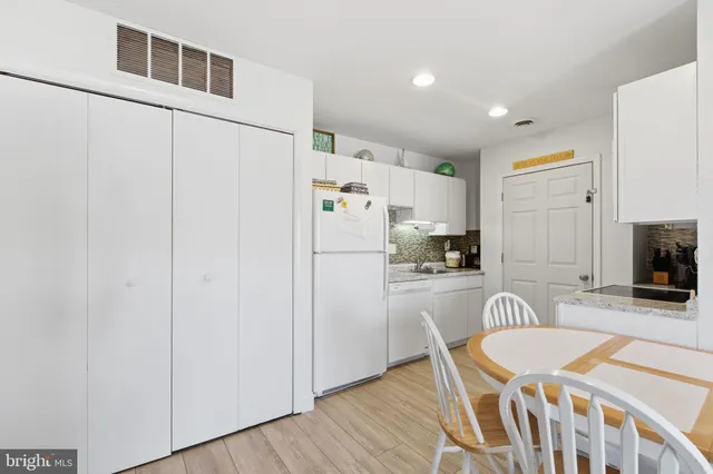 a kitchen with stainless steel appliances granite countertop a refrigerator a stove a sink dishwasher and a refrigerator with wooden floor