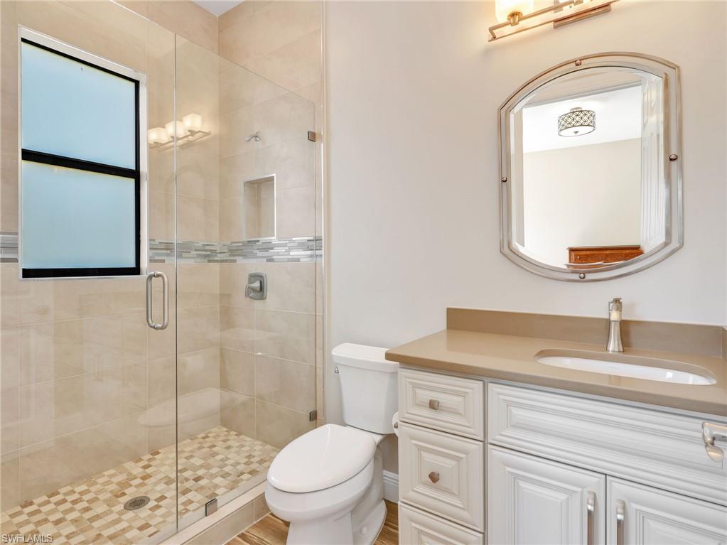 3160 27th Avenue Southwest Naples, FL 34117 - Photo 31 of 43 a bathroom with a toilet sink vanity and mirror