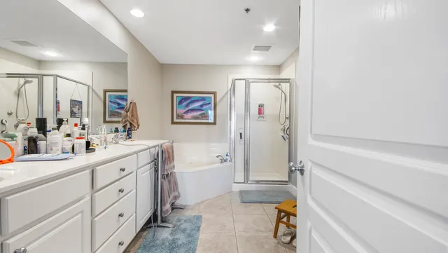 a bathroom with a double vanity sink a mirror a bathtub and shower