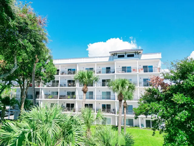 a front view of a multi story residential apartment building with a yard