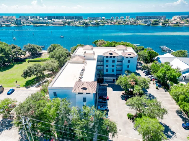 an aerial view of a house with a garden and lake view