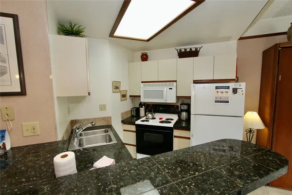 a kitchen with a refrigerator and a stove top oven