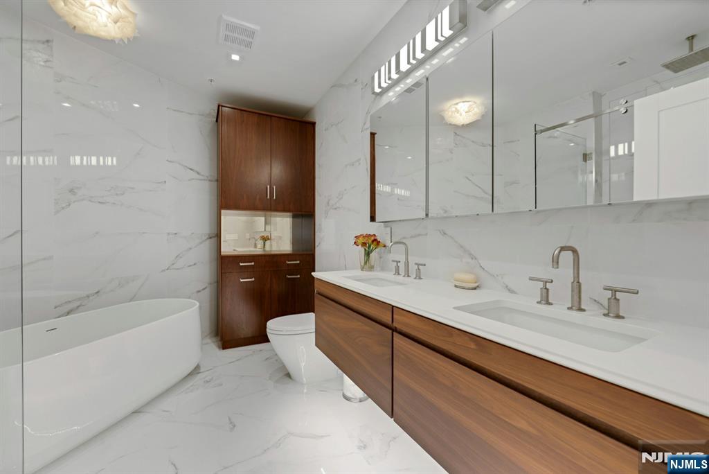 22 Ave At Port Imperial, Unit 114 West New York, NJ 07093 - Photo 22 of 39 a bathroom with a tub sink and mirror