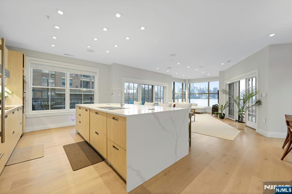 22 Ave At Port Imperial, Unit 114 West New York, NJ 07093 - Photo 5 of 39 a large white kitchen with center island and stainless steel appliances