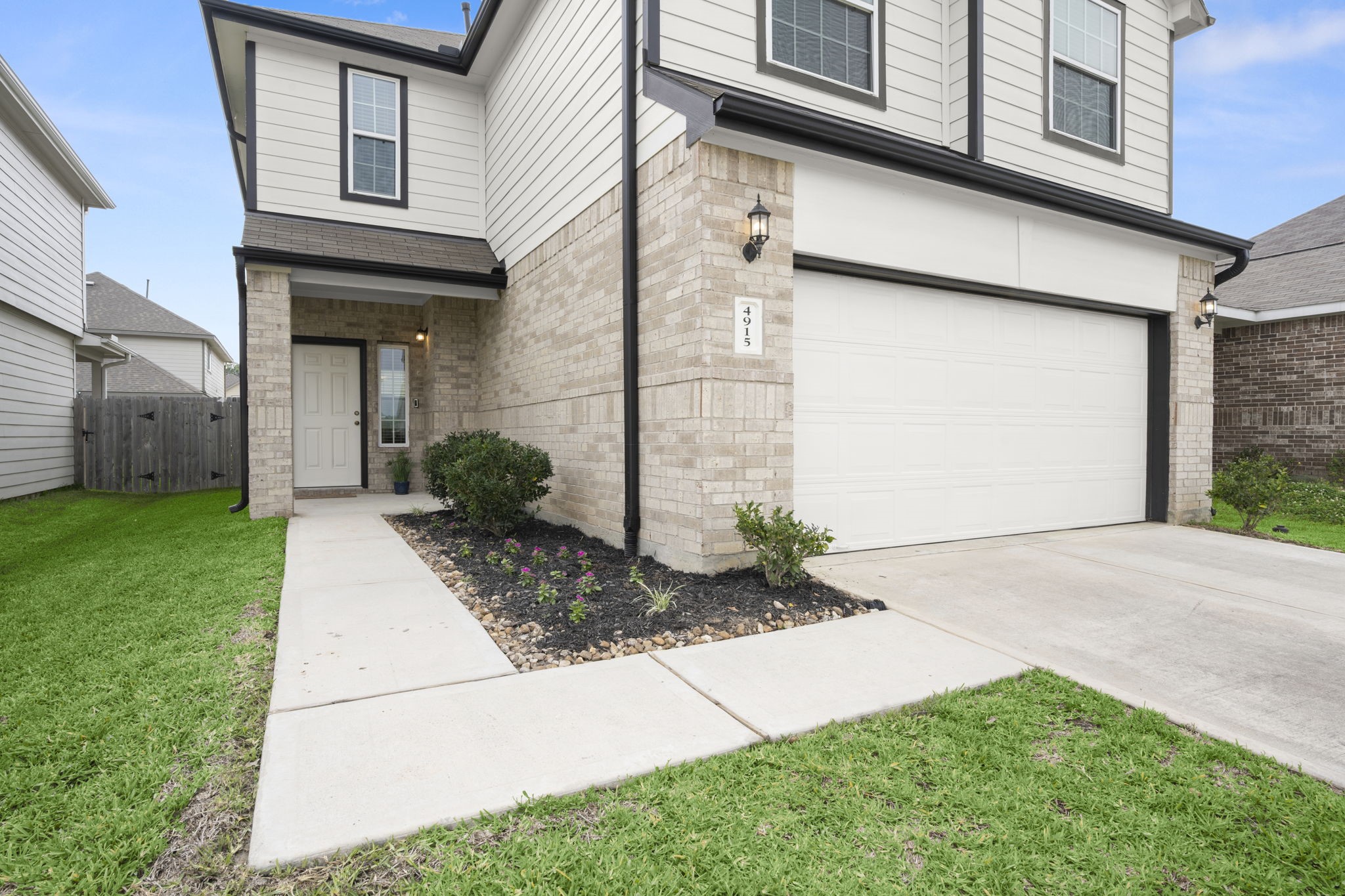 4915 Blue Jacaranda Way Spring, TX 77373 - Photo 1 of 30 This modern exterior home features a neatly landscaped front yard, covered entry, address plaque, sconce lighting and a spacious two-car garage.