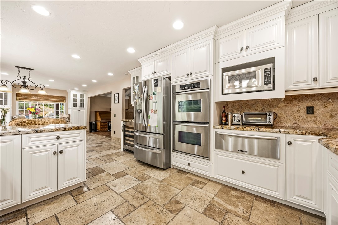 1485 Vía Ladera Fallbrook, CA 92028 - Photo 15 of 43 a kitchen with stainless steel appliances a refrigerator sink and cabinets