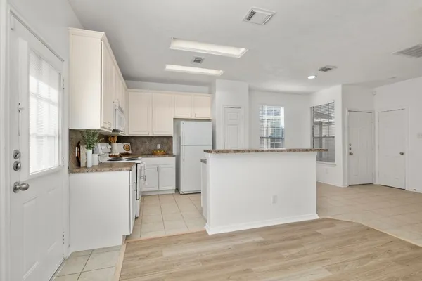 a kitchen with white cabinets and stainless steel appliances