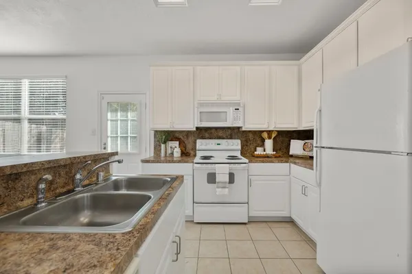 a kitchen with granite countertop a sink stove and refrigerator
