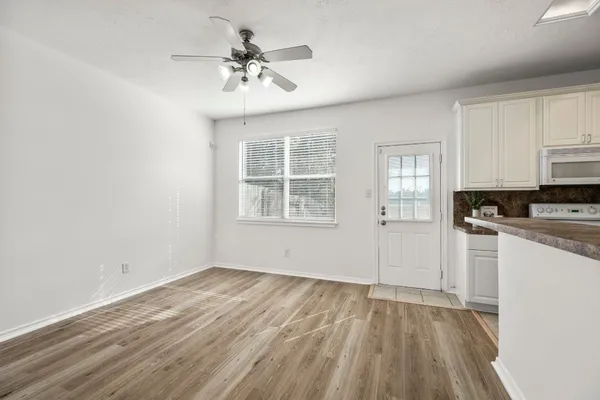 a view of a kitchen with wooden floor and a window