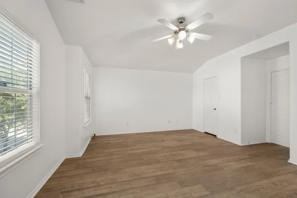 wooden floor in an empty room with a chandelier fan