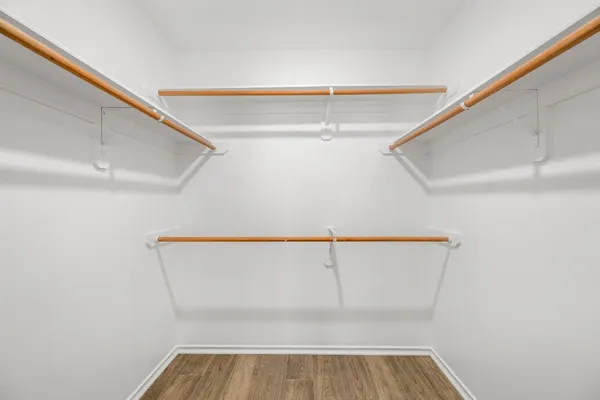 a view of walk in closet with empty racks